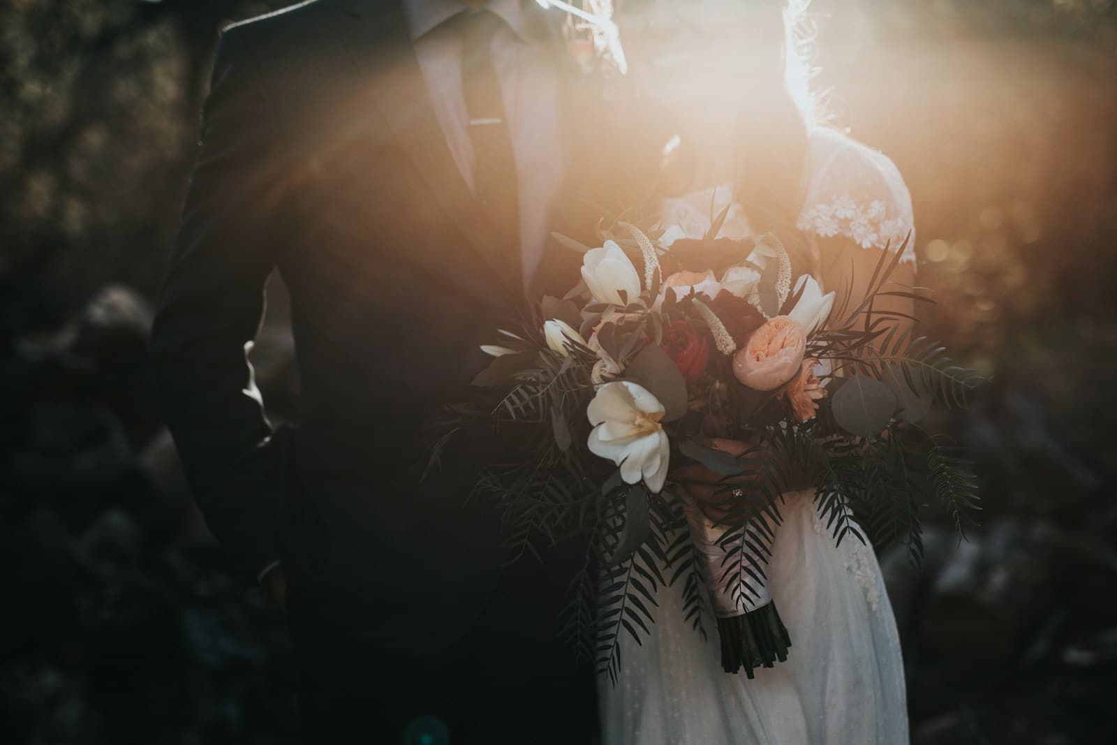 Couple de mariés tenant un bouquet de fleurs